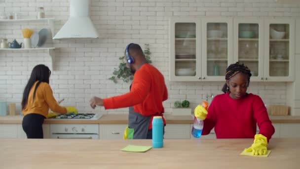 Carefree pai desfrutando de música enquanto menina limpeza cozinha — Vídeo de Stock