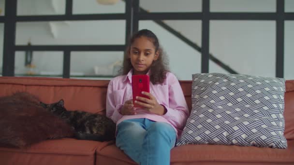 Χαριτωμένο κορίτσι της Αφρικής λαμβάνοντας selfie με τη γάτα στο σπίτι — Αρχείο Βίντεο