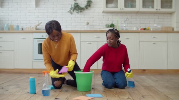 Gadis remaja kulit hitam positif membersihkan lantai bersama-sama — Stok Video
