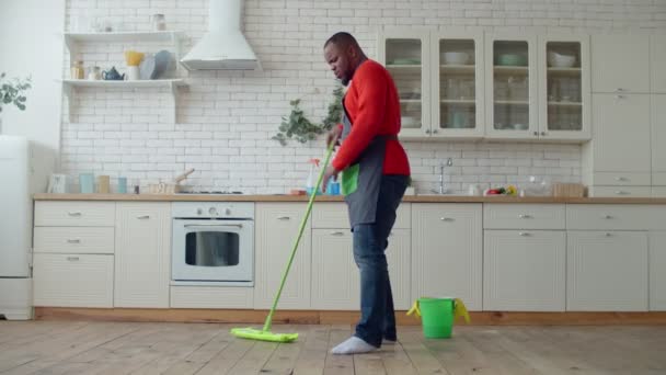 Pria afrika yang riang bersenang-senang selama mengepel — Stok Video