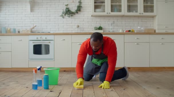 Çalışkan Afrikalı erkek evde yerleri siliyor. — Stok video