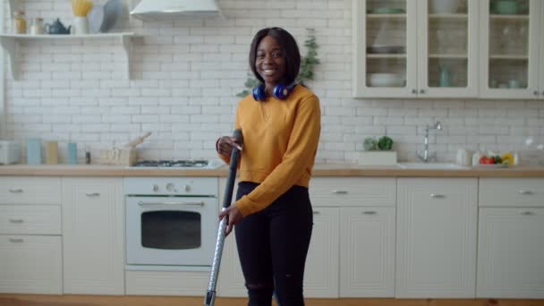 Πορτρέτο του μαύρου κορίτσι housekeping με ηλεκτρική σκούπα — Αρχείο Βίντεο