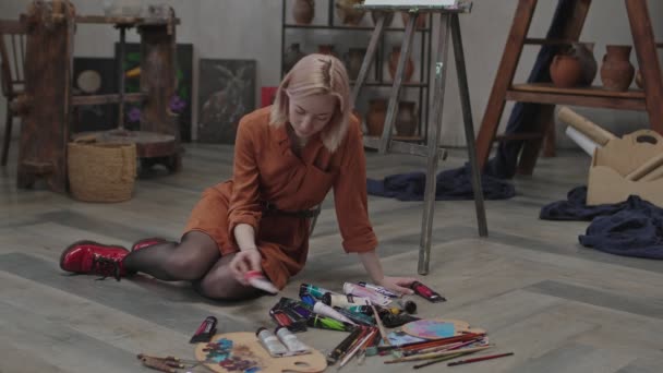 Жінка-художник вибирає акрилові фарби для картини — стокове відео