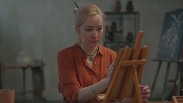 Обдарована жінка живописець створює олійний живопис на мольберті — стокове відео