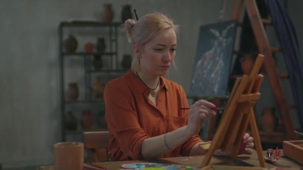 Female painter creating colorful abstract artwork in studio — Stock Video