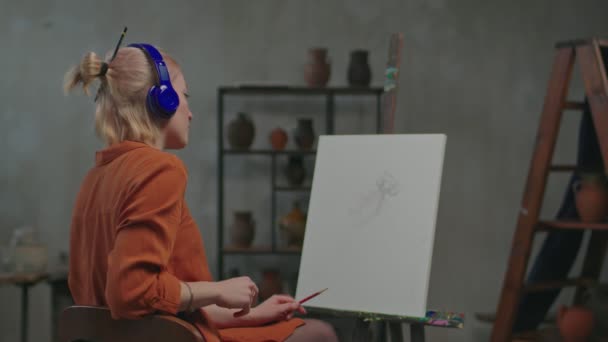 Artis wanita di headphone mencari inspirasi dalam musik — Stok Video
