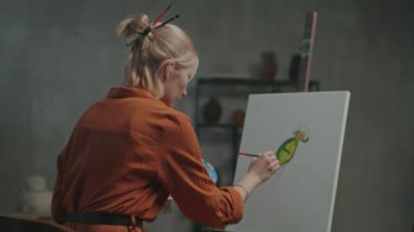 Yetenekli kadın ressam yağlı boyalarla sanat eseri yapıyor.