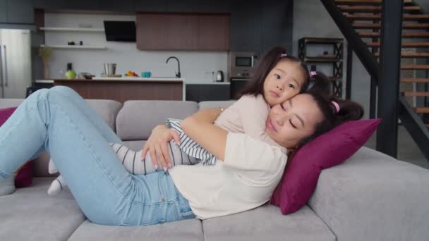 Heureux asiatique mère et mignon bébé fille collage sur canapé — Video