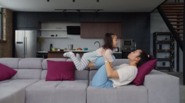 Mutlu Asyalı anne ve kız bebek evde eğleniyor.