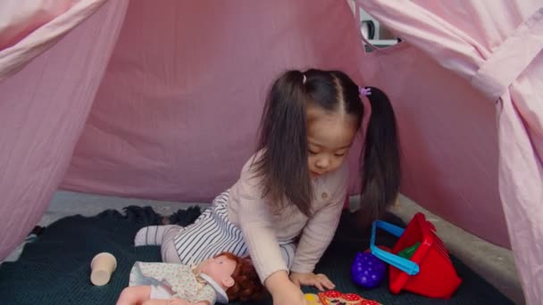 Ocupado asiático niña disfrutando de jugar en tipi tienda de campaña — Vídeo de stock
