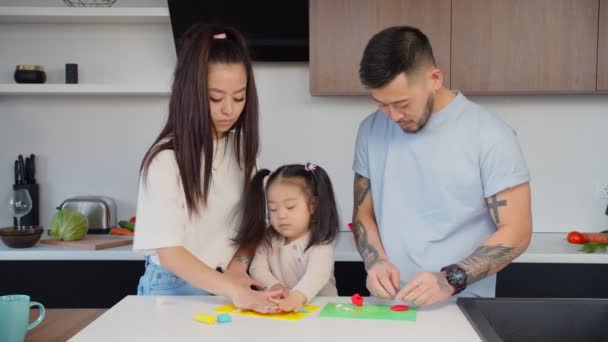 Догляд за азіатськими батьками та дитячим моделюванням з барвистим пластиліном — стокове відео