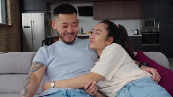 Portret van gelukkig aziatisch getrouwd paar ontspannen op de bank — Stockvideo