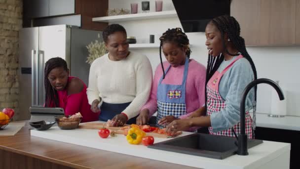 Afrikalı bir anne genç kızlara yemek yapmayı öğretiyor. — Stok video