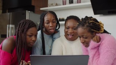 Afrikalı anne kızlarıyla aile videosu izliyor.