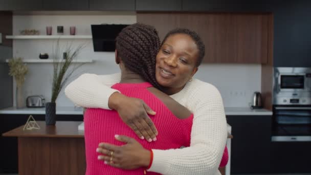 Vårdande svart mor omfamnar tonårsdotter inomhus — Stockvideo