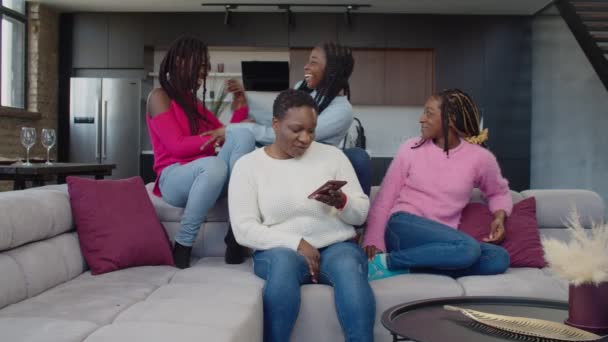 Fröhlich vereinte schwarze Familie entspannt auf Sofa zu Hause — Stockvideo