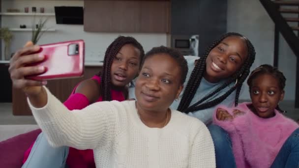 Joyful black family with smartphone making selfie at home — стоковое видео