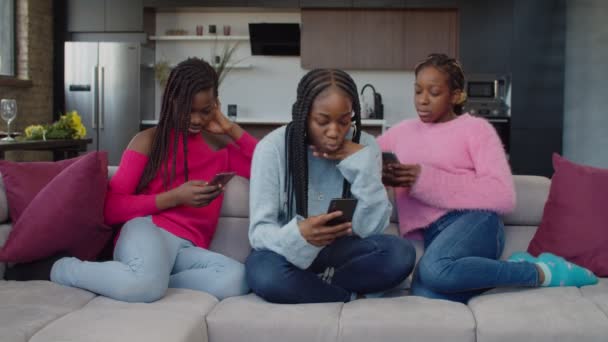 Залежні від мобільних телефонів дівчата-підлітки пхають один одного в приміщенні — стокове відео