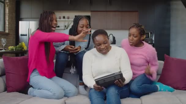 Familia alegre con tres chicas adolescentes haciendo videollamada con tablet pc — Vídeo de stock