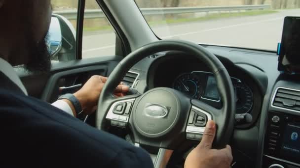 Modern arabanın direksiyonundaki siyah erkek elinin yakın çekimi. — Stok video