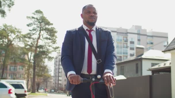 Eco amigável empresário africano viajando para o trabalho de scooter elétrico — Vídeo de Stock