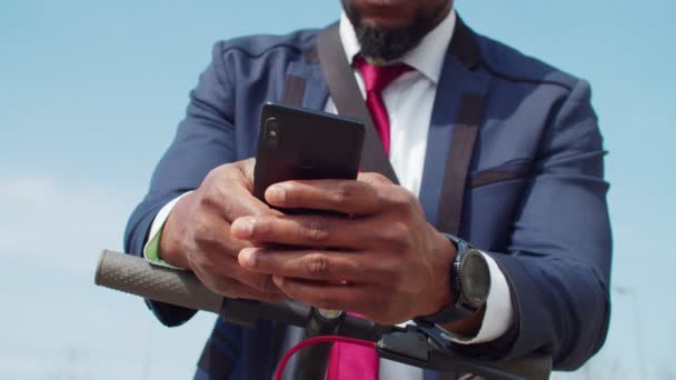 Homem usando smartphone para alugar e-scooter para comutar — Vídeo de Stock