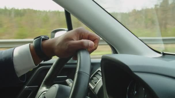 A kormánykereket vezetés közben tartó fekete férfi vezető keze — Stock videók