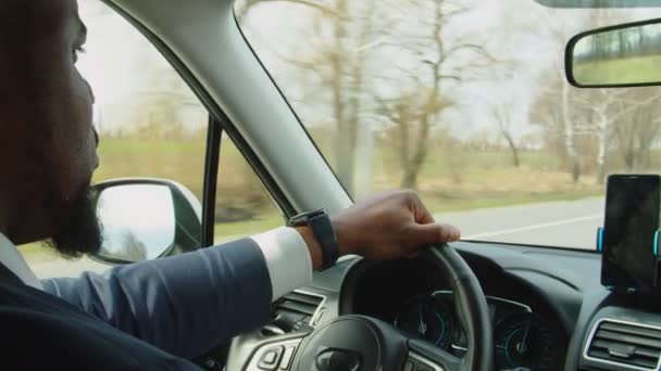 Selbstbewusster Afroamerikaner im Anzug fährt Auto auf Autobahn — Stockvideo