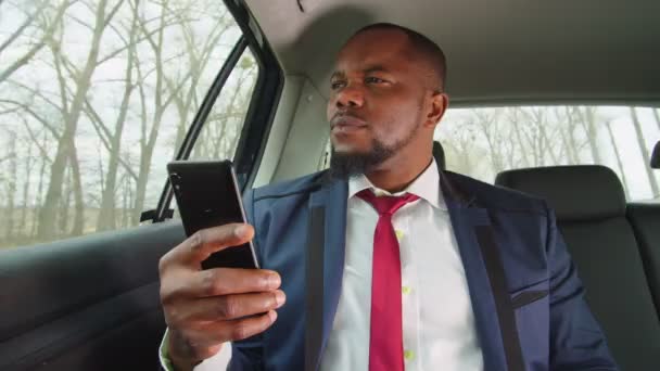 Animando a hombre de negocios negro con el teléfono celebrando el éxito en el coche — Vídeos de Stock