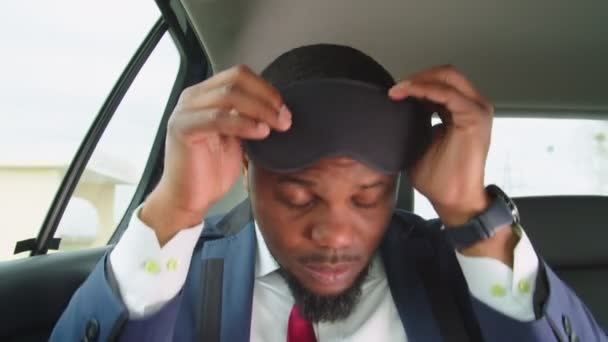Cansado persona de negocios que se pone la máscara del sueño para dormir en el coche — Vídeos de Stock