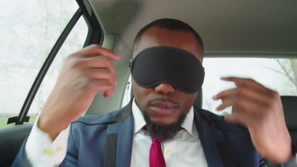 Svart affärsman vinna sömn mask vakna upp i baksätet på bilen — Stockvideo