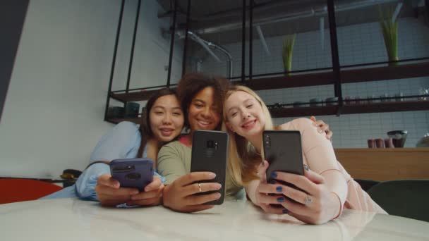 Zorgeloze multi-etnische vrouwen nemen selfie shot in coffeeshop — Stockvideo