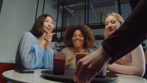 Serveerster serveert koffie aan multi-etnische vrouwelijke klanten in cafe — Stockvideo