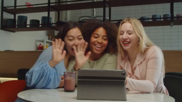 Preciosas mujeres multirraciales haciendo videollamada en la tableta PC en la cafetería — Vídeos de Stock