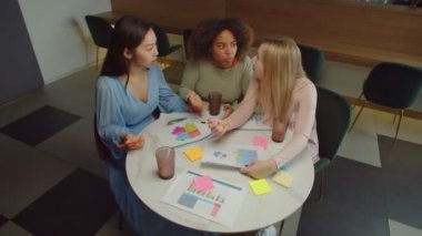 Kafe 'deki toplantıda çok ırklı kadın işçiler tartışıyor