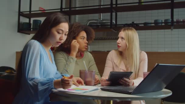 Líder da equipe feminina negra discutindo assuntos de negócios com colegas de trabalho no café — Vídeo de Stock