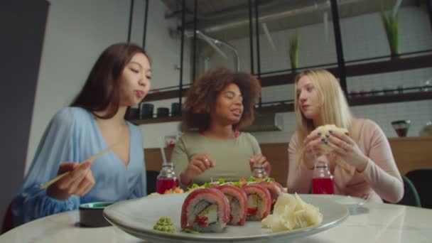 Jolie asiatique femme manger savoureux sushi pendant déjeuner avec copines — Video