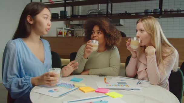 Positieve multiraciale vrouwen toasten met koffiekopjes in café — Stockvideo