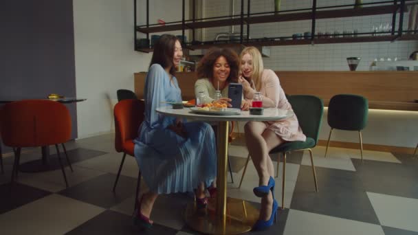 Carefree multiethnic women posing for selfie in coffee shop — стоковое видео