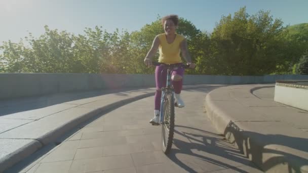 Gioiosa bella donna nera in bicicletta in città all'alba — Video Stock