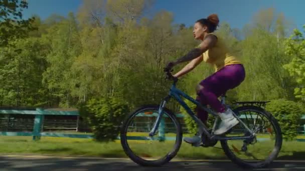 漂亮的黑人女人享受着积极的生活，骑自行车在户外 — 图库视频影像