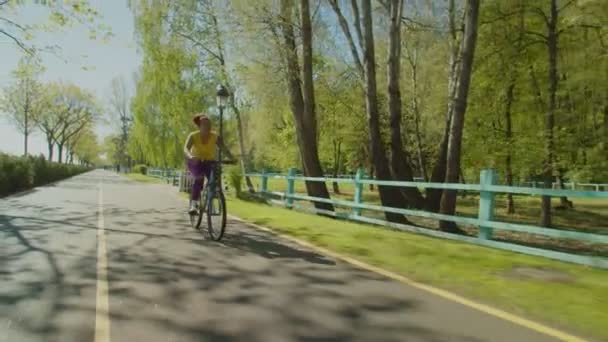Aktif, güzel siyah kadın bisikletçi yaz parkında bisiklet sürmekten zevk alıyor. — Stok video