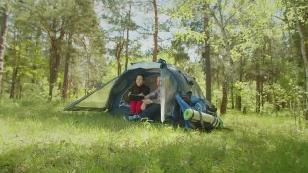 Ontspannen wandelaar paar netwerken op tablet pc in kamp tent — Stockvideo