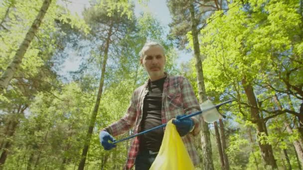 Ecológico voluntarios maduros limpieza de bosques de residuos plásticos — Vídeo de stock