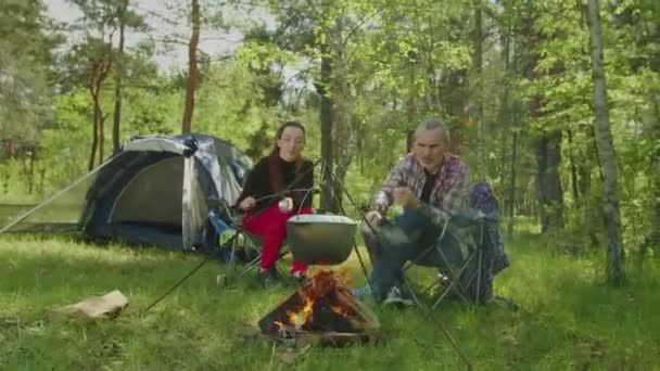 Happy hiker couple roasting marshmallows on campfire — 图库视频影像