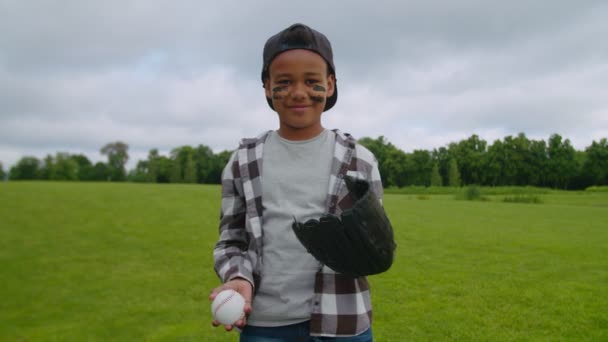 Lachende jongen werper gooit honkbal bal in honkbal handschoen — Stockvideo