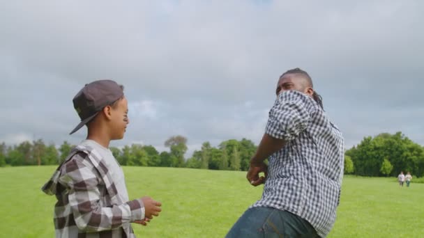 Søt svart sønn med pappa som lærer å kaste baseball utendørs – stockvideo
