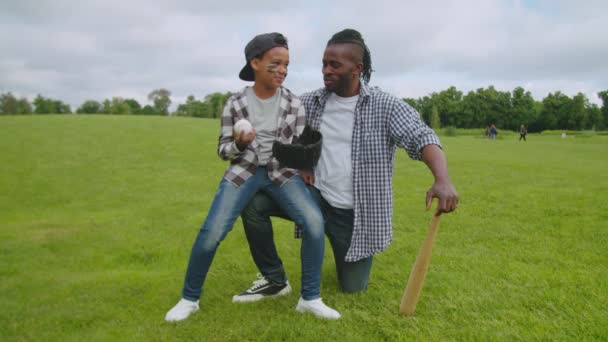 Attivo padre e figlio nero che si godono la partita di baseball nel parco — Video Stock