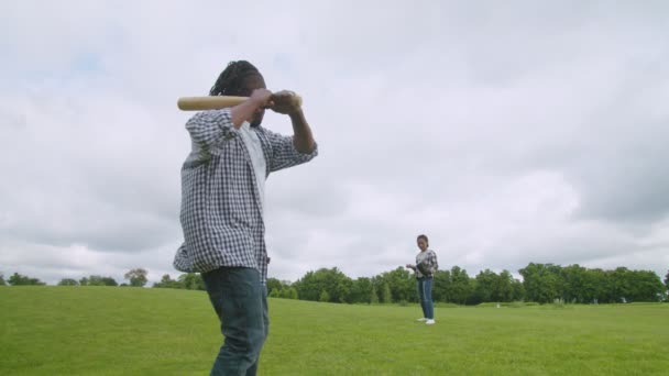 वडिलांसोबत बेसबॉल खेळत असताना आनंदी आफ्रिकन मुलगा पिचर स्ट्राइक करत आहे — स्टॉक व्हिडिओ