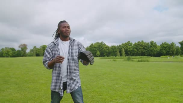 Aktivní pohledný africký muž chycení míč v baseballové rukavici venku — Stock video